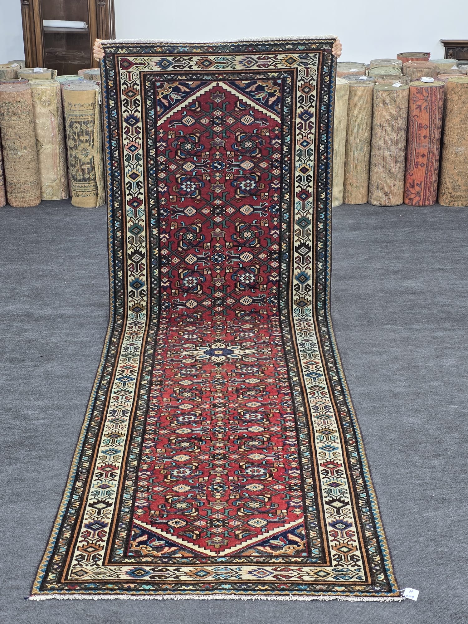 Vintage hand-knotted Turkish runner rug with a vibrant red field, intricate geometric patterns in blue, beige, and multicolor accents. Ideal for hallways, kitchens, or entryways.
